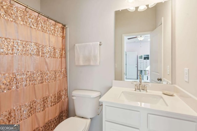 bathroom featuring ceiling fan, vanity, a shower with shower curtain, and toilet