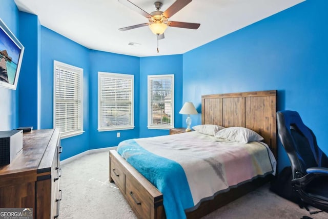 carpeted bedroom with multiple windows and ceiling fan