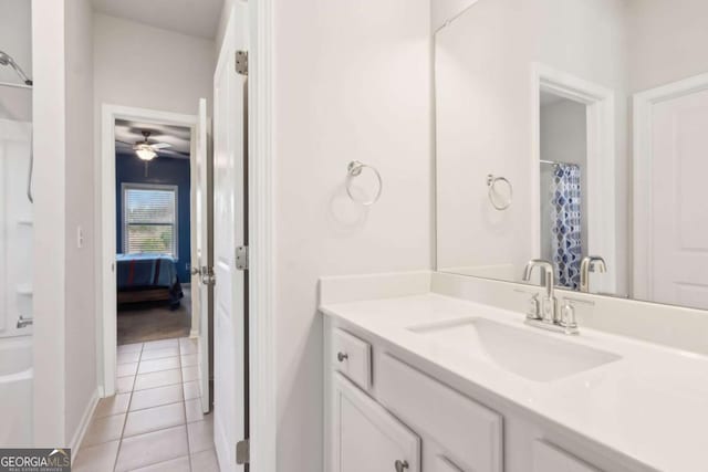 bathroom with tile patterned flooring, ceiling fan, walk in shower, and vanity