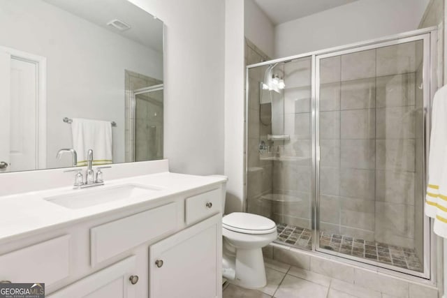 bathroom featuring tile patterned floors, vanity, an enclosed shower, and toilet