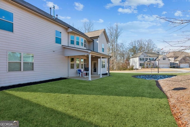 rear view of house with a lawn and a patio area