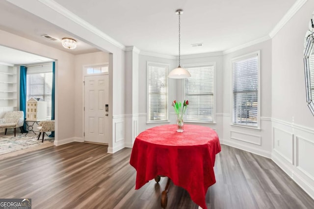 dining area with dark hardwood / wood-style flooring, built in features, and crown molding