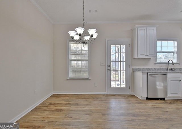 unfurnished dining area with a chandelier, a healthy amount of sunlight, and ornamental molding