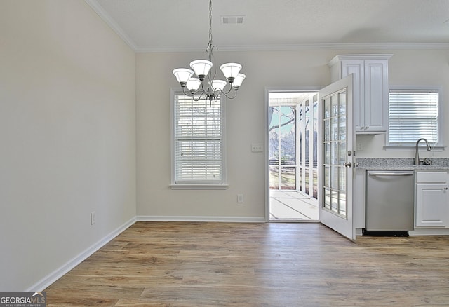 unfurnished dining area with crown molding, light hardwood / wood-style flooring, sink, and a notable chandelier