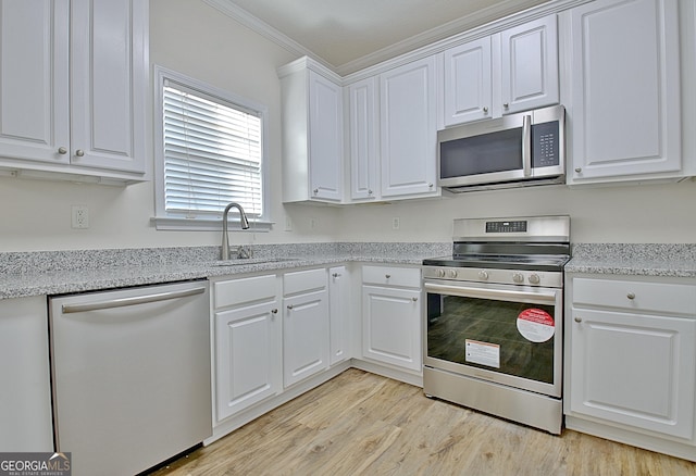 kitchen with white cabinetry, sink, light stone counters, and appliances with stainless steel finishes