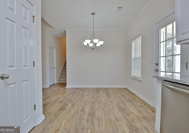 unfurnished dining area with light hardwood / wood-style floors, crown molding, and a chandelier