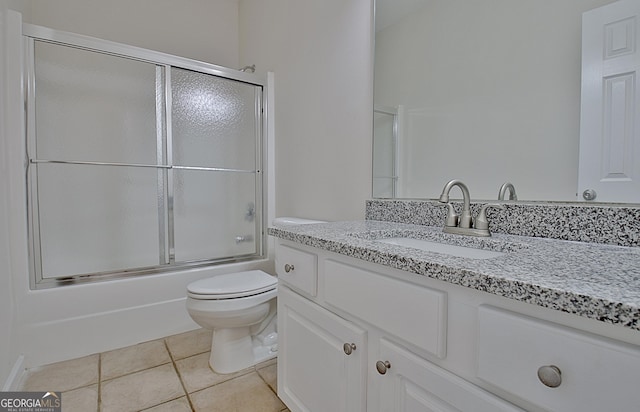 full bathroom with tile patterned floors, vanity, toilet, and shower / bath combination with glass door