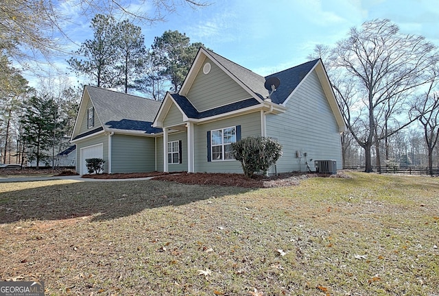 view of side of home featuring cooling unit, a garage, and a yard