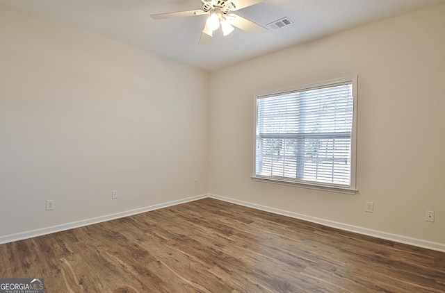 empty room featuring dark hardwood / wood-style flooring and ceiling fan