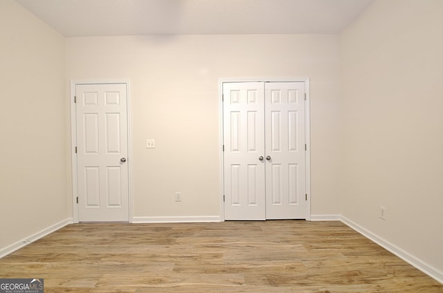 unfurnished bedroom with a closet and light hardwood / wood-style flooring