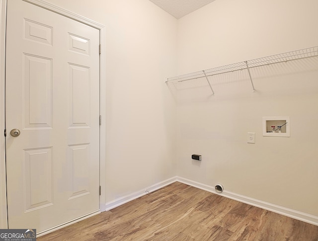 washroom featuring electric dryer hookup, washer hookup, a textured ceiling, and hardwood / wood-style flooring