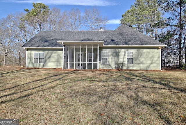 rear view of house with a sunroom and a lawn