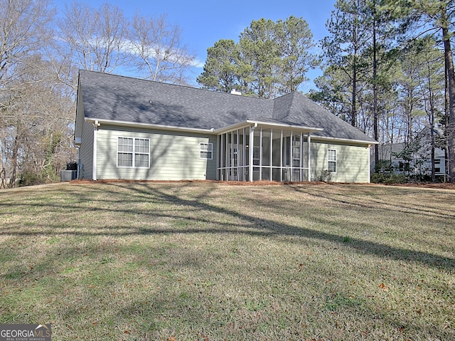 rear view of property with a lawn, cooling unit, and a sunroom