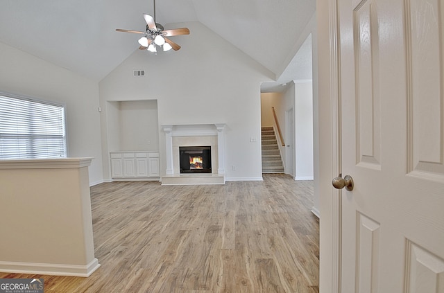 unfurnished living room featuring ceiling fan, light wood-type flooring, and lofted ceiling