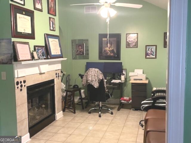 tiled home office with ceiling fan and a tile fireplace