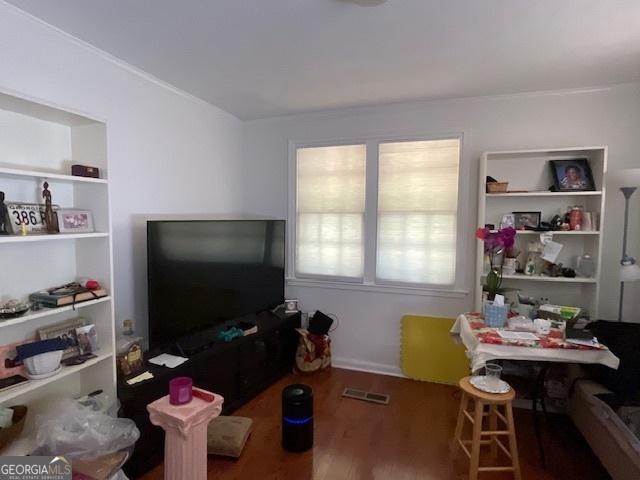 interior space with built in shelves and wood-type flooring