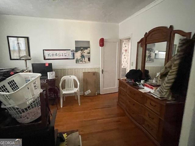 bedroom featuring wood-type flooring and ornamental molding