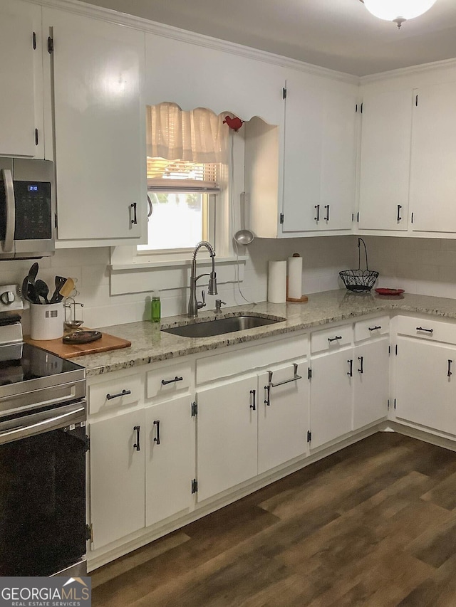 kitchen with sink, crown molding, white cabinetry, stainless steel appliances, and dark hardwood / wood-style floors