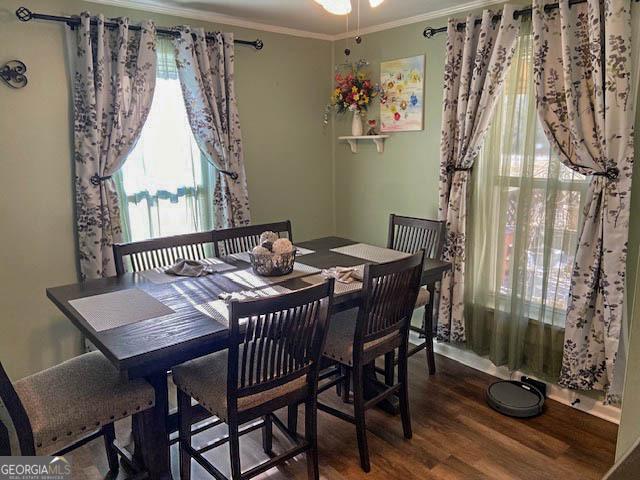 dining room with crown molding, a healthy amount of sunlight, and hardwood / wood-style floors