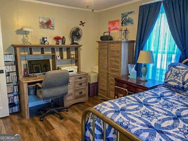 bedroom featuring dark wood-type flooring and ornamental molding