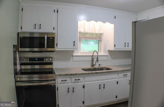 1812 Barnesville Hwy, Thomaston, GA 30286 - kitchen featuring appliances with stainless steel finishes, a sink, decorative backsplash, and white cabinetry