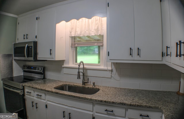 1812 Barnesville Hwy, Thomaston, GA 30286 - kitchen with appliances with stainless steel finishes, a sink, crown molding, white cabinetry, and tasteful backsplash