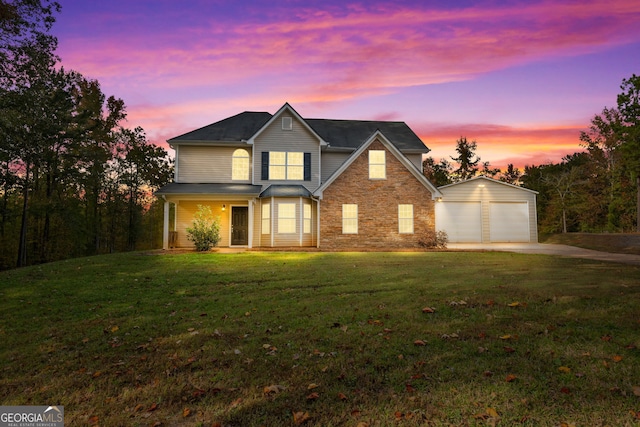 view of front of home featuring a lawn, a garage, and an outbuilding