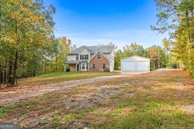 view of front of property featuring a garage, a front lawn, and an outdoor structure