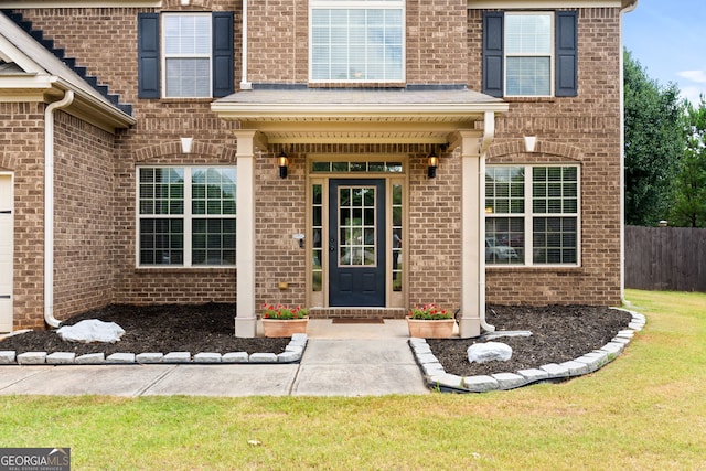 entrance to property featuring a lawn