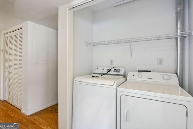 washroom with light hardwood / wood-style floors and washing machine and dryer