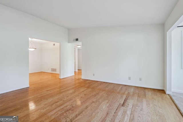 unfurnished bedroom with light hardwood / wood-style floors and lofted ceiling