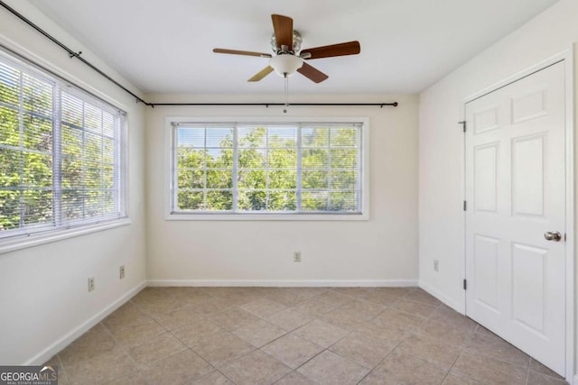 tiled empty room with ceiling fan