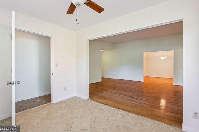 empty room with ceiling fan and light hardwood / wood-style flooring