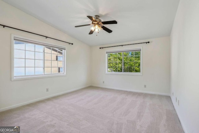 spare room with light carpet, lofted ceiling, ceiling fan, and a healthy amount of sunlight