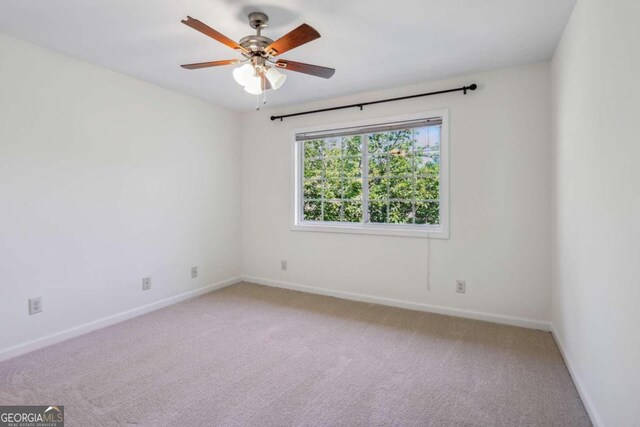 carpeted spare room featuring ceiling fan