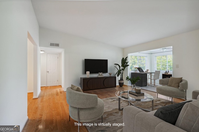 living room featuring light wood-type flooring and lofted ceiling