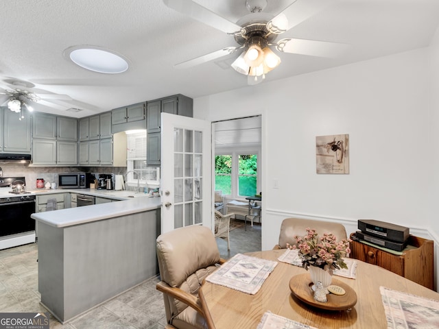 kitchen featuring sink, ceiling fan, appliances with stainless steel finishes, tasteful backsplash, and kitchen peninsula