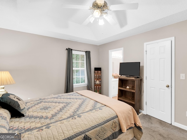 bedroom with carpet flooring, ceiling fan, and a tray ceiling