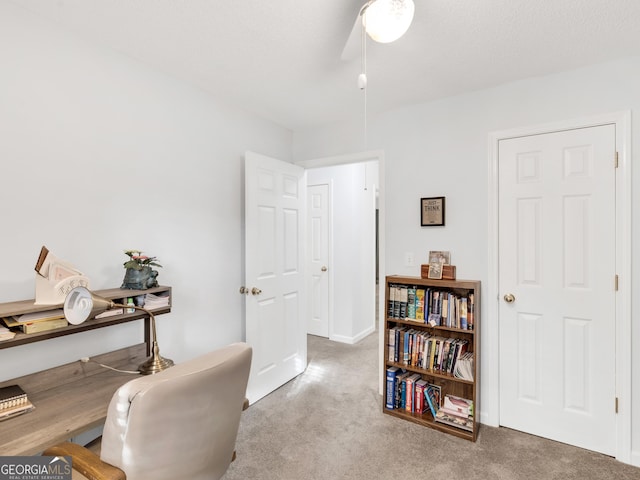 carpeted office space featuring ceiling fan