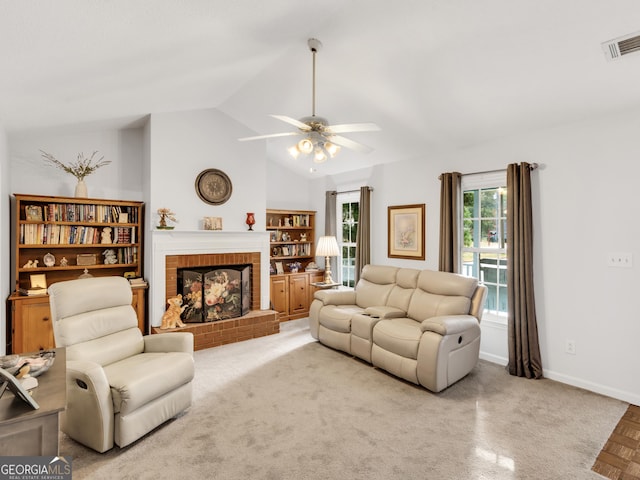 living room featuring a brick fireplace, ceiling fan, and lofted ceiling