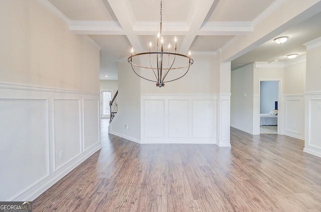 interior space with beamed ceiling, wood finished floors, stairs, a decorative wall, and a notable chandelier