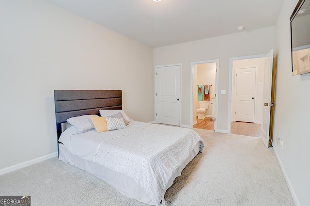 bedroom with light carpet, connected bathroom, and baseboards