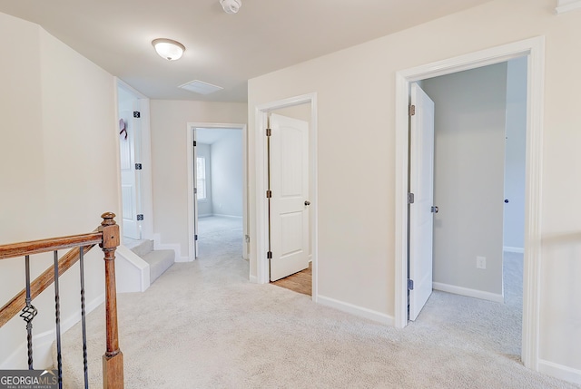 hall featuring light carpet and baseboards