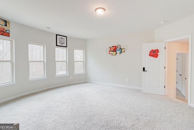 unfurnished room featuring baseboards, visible vents, and light colored carpet