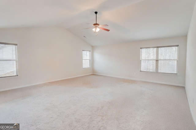 empty room with carpet floors, baseboards, vaulted ceiling, and a ceiling fan