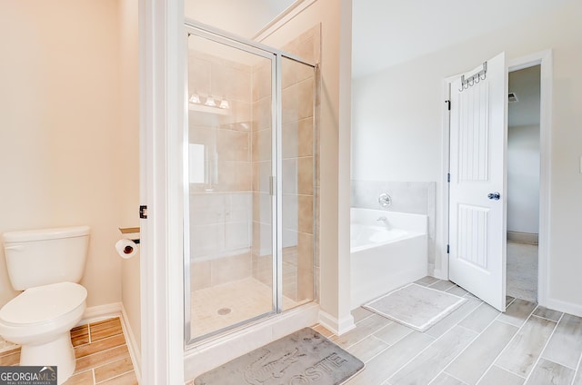 bathroom with toilet, baseboards, a shower stall, a bath, and wood tiled floor