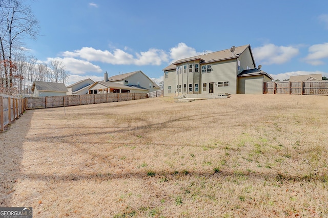 back of house with a fenced backyard, a yard, and a patio