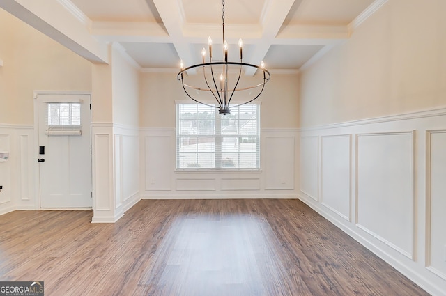 unfurnished dining area featuring a notable chandelier, a decorative wall, beamed ceiling, and wood finished floors