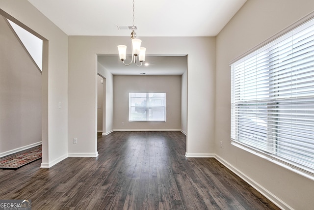 unfurnished dining area with dark hardwood / wood-style floors and a chandelier