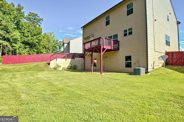 back of property with a wooden deck, central AC unit, and a lawn